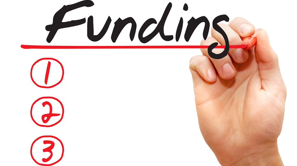 Stock image showing the word "funding" being written with a marker